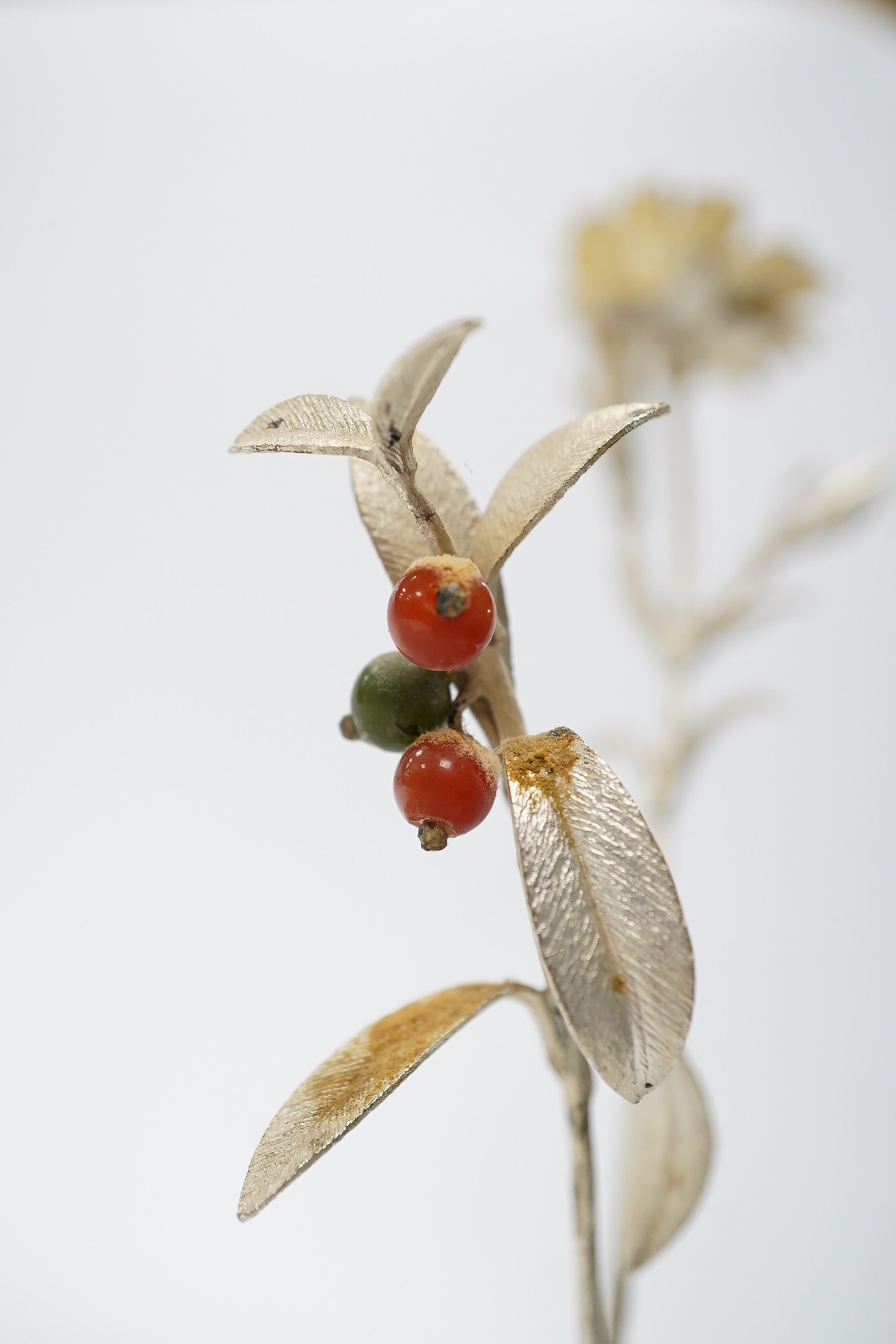 A 1980's silver gilt holly sprig and similar carnation, 15.7cm, in an Orrefors vase ornament, Condition - fair to good